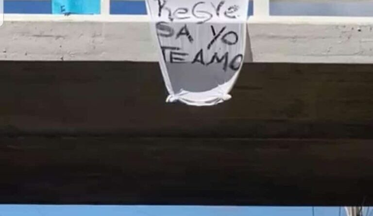 Con cartel colocado en un puente hombre pide a pareja que regrese